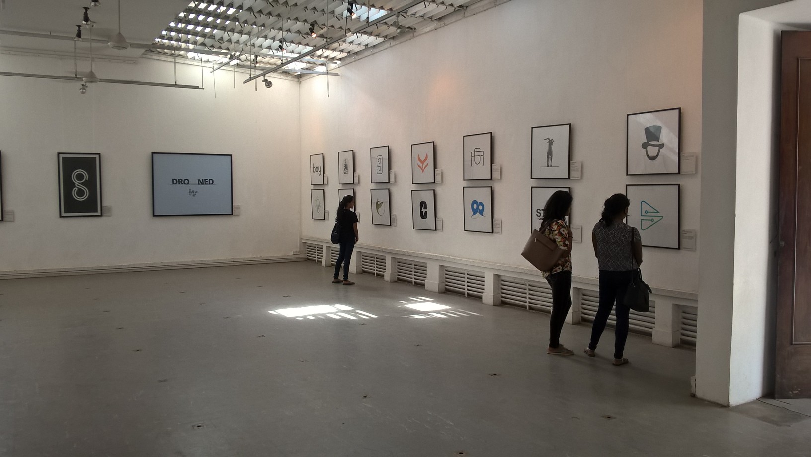 Visitor viewing a framed flying bird logo print at the SIMPLICITY exhibition